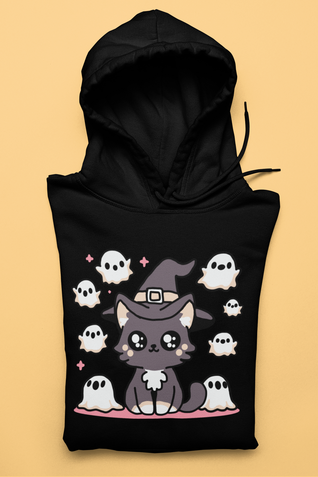 Black hoodie with a cute cat in a witch hat surrounded by ghosts on a beige background