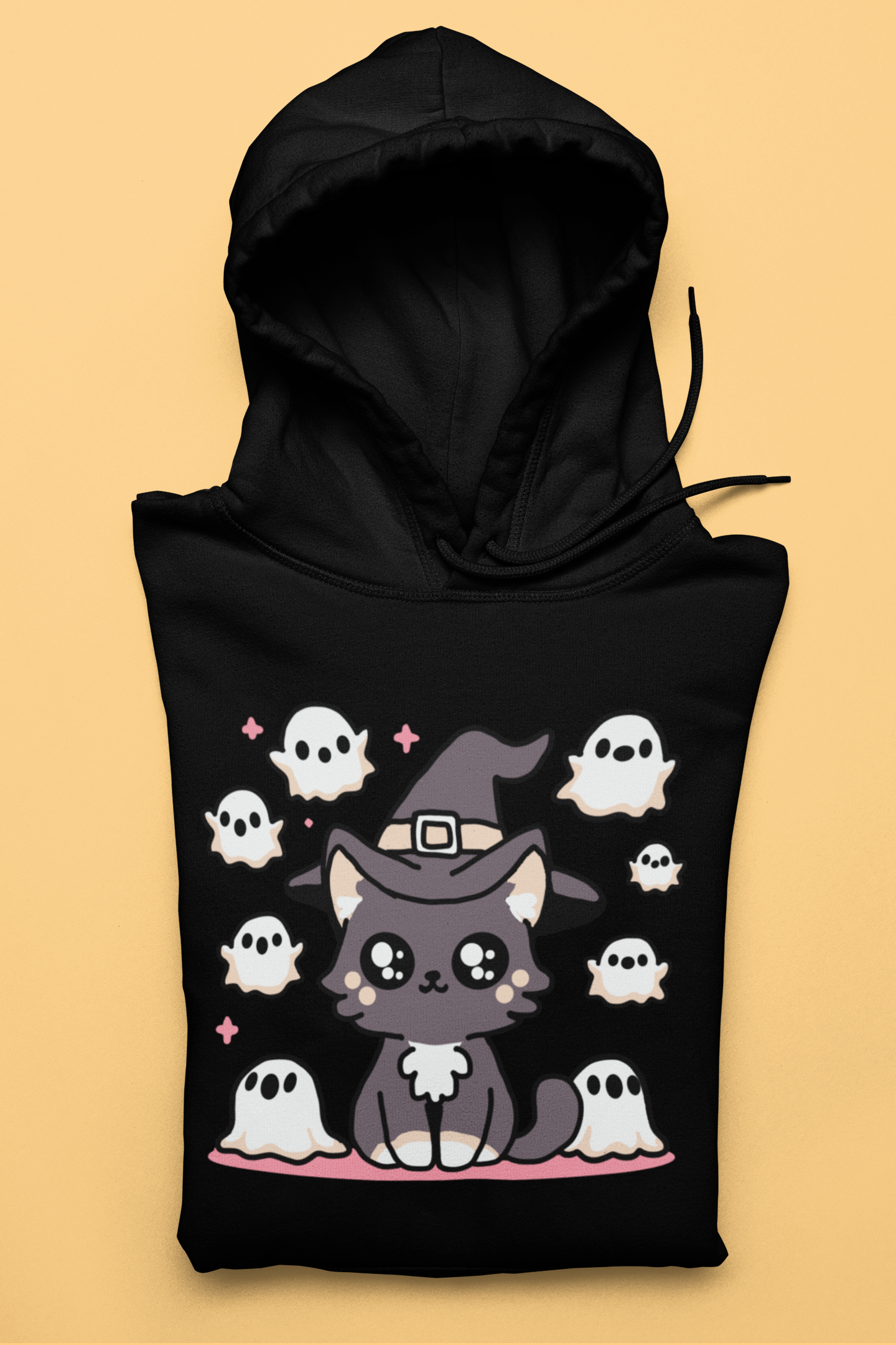 Black hoodie with a cute cat in a witch hat surrounded by ghosts on a beige background